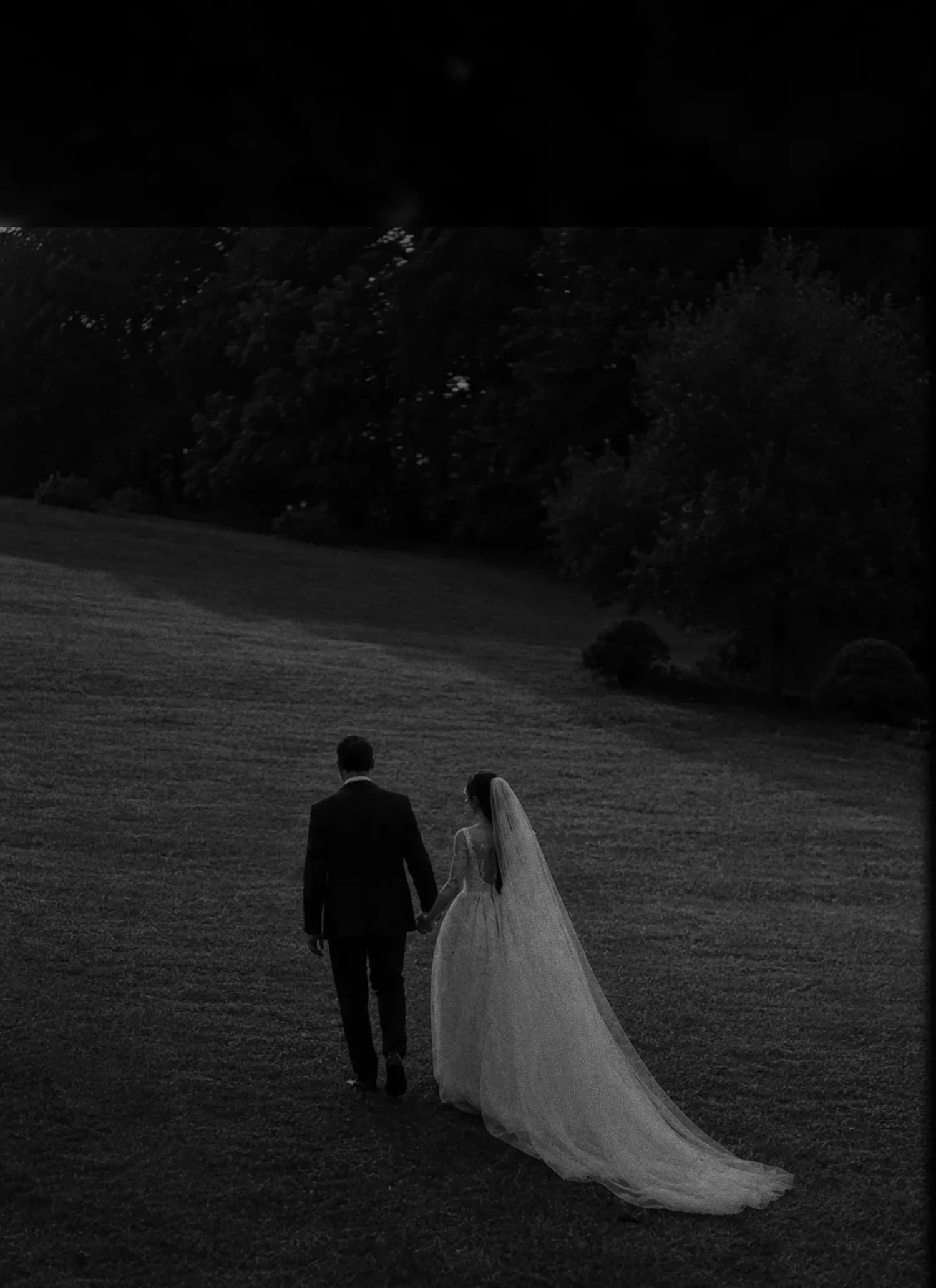 Los novios alejándose de la mano al caer la noche